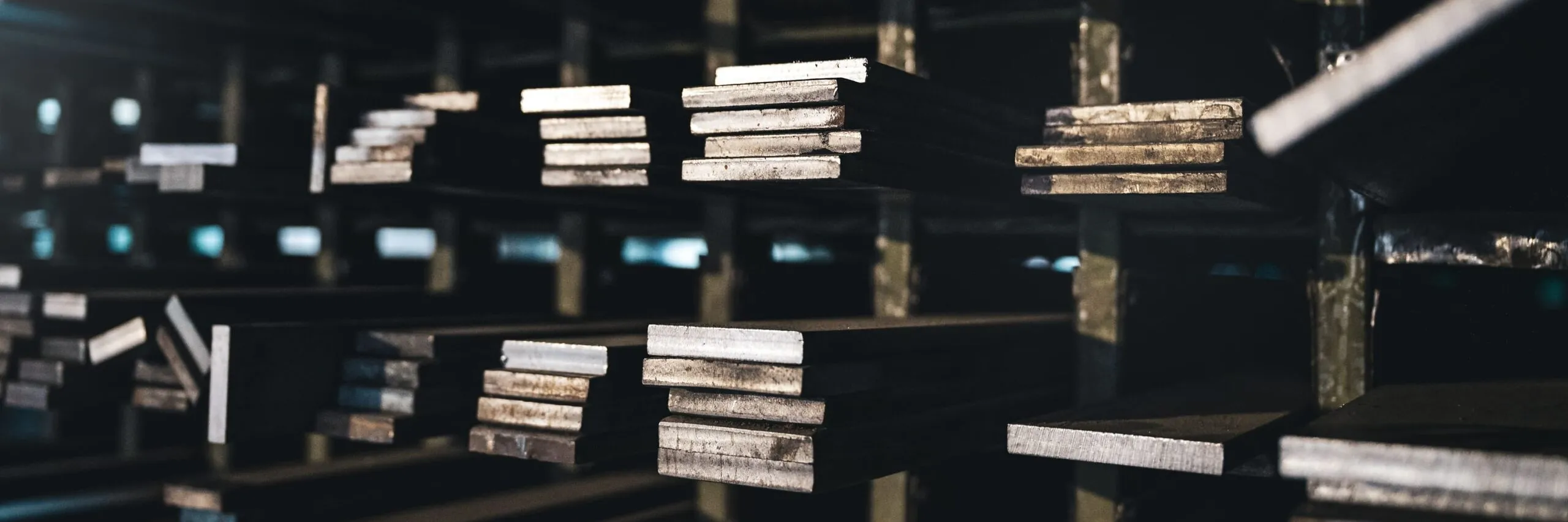 Reihen von Stahlträgern lagern in einem dunklen Lager einer Metallbau-Firma in Südtirol.