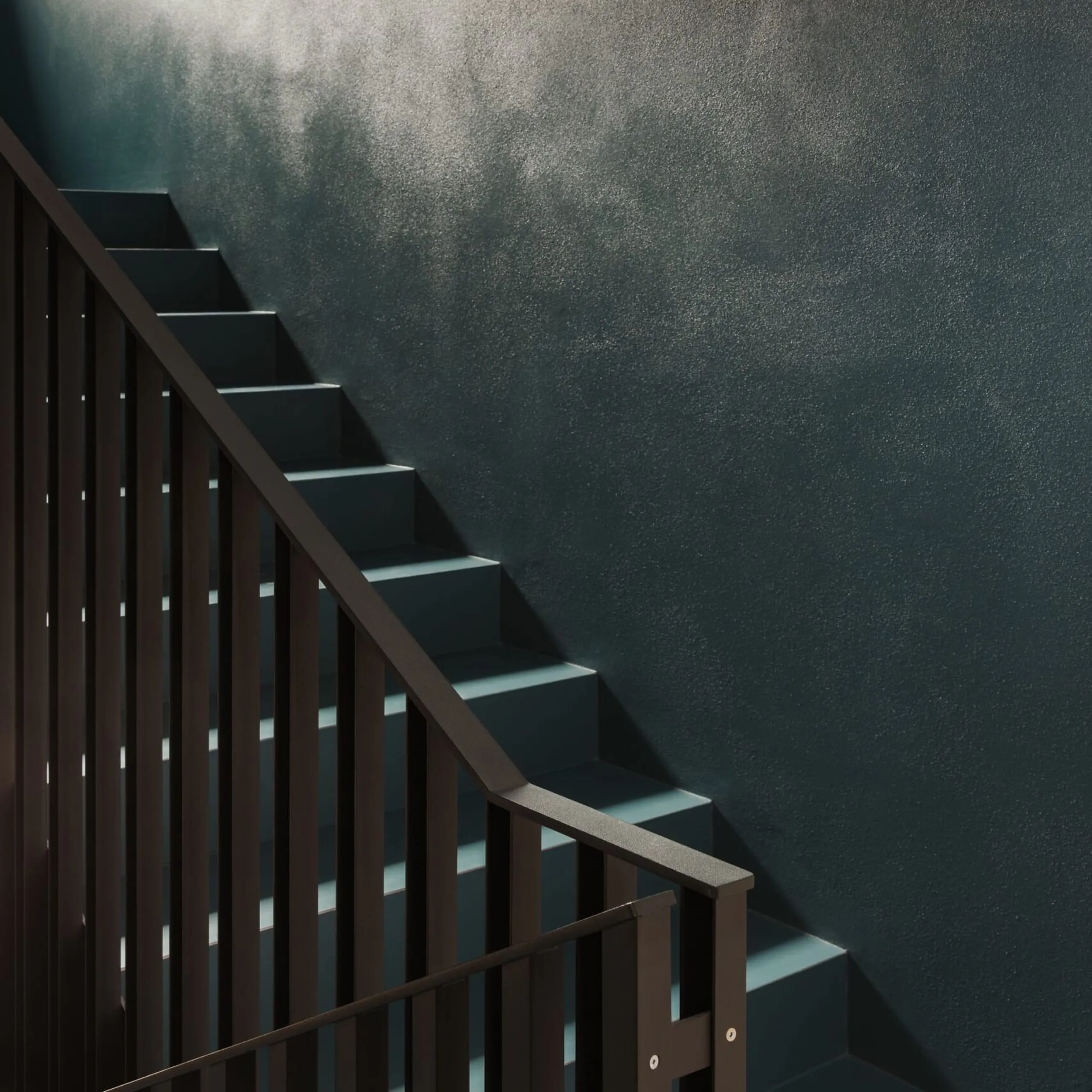 Innenstiege mit dunkelgrauer Metalltreppe und braunem Geländer vor einer texturierten, dunklen Metallwand; Licht fällt von links auf die Stufen.